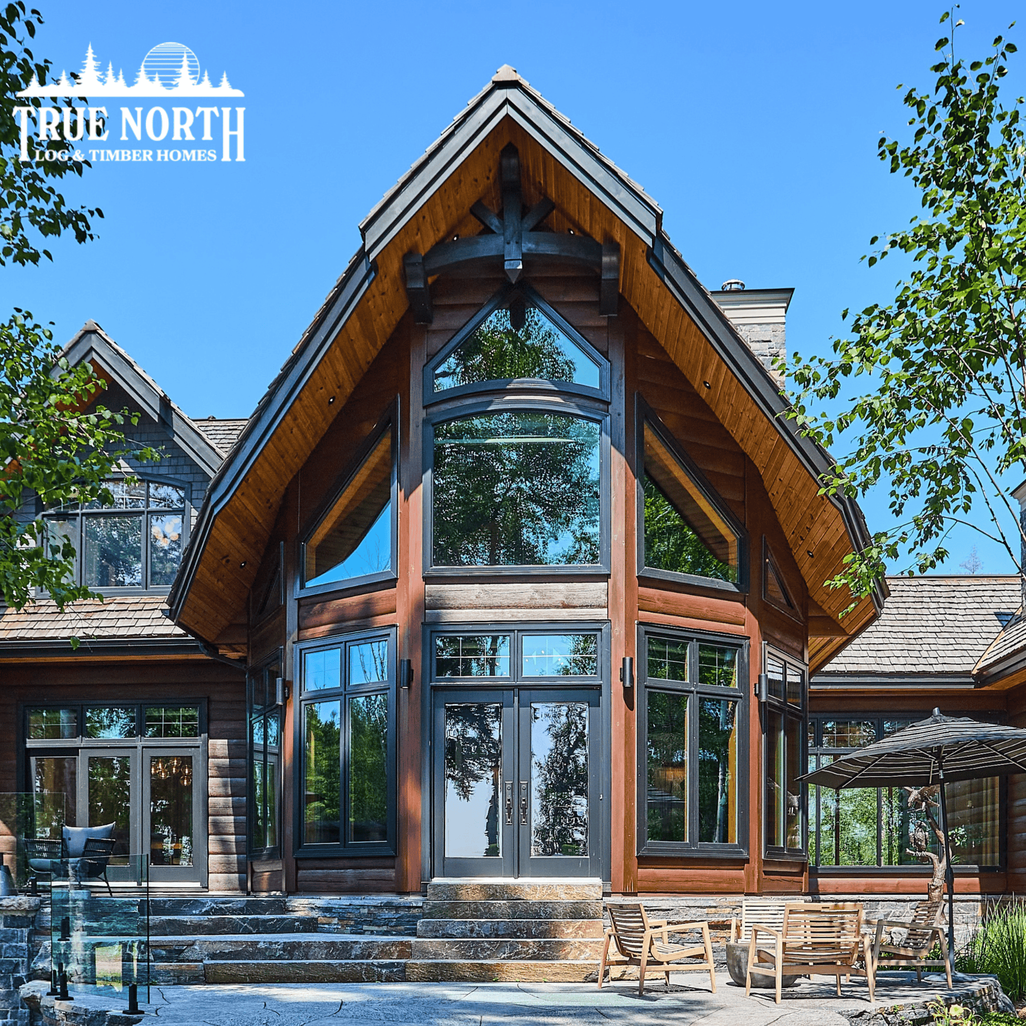 The image shows the great rooms windows of the Colantonio Residence. The great room looks out onto a granite stone patioo, on a beautiful sunny day. 