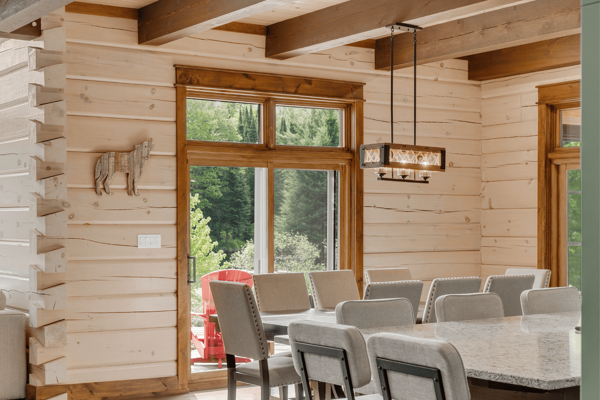 The dining room of the award-winning Riverview by True North Log & Timber Homes. The whitewashed walls brighten the space and balances the warmth of wood.